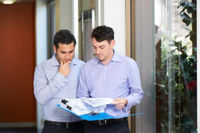 Male students looking into file