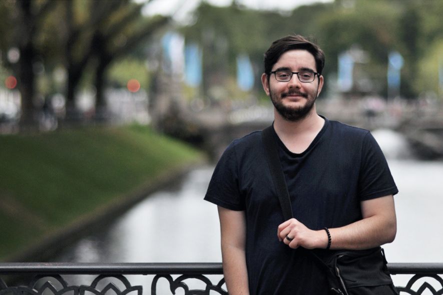 Student standing outside bridge